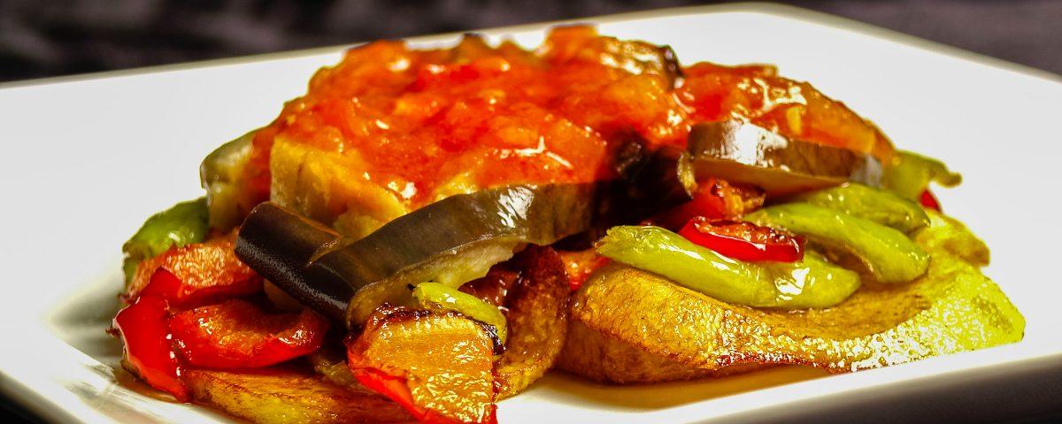 A plate of one of Majorca's local dishes, tombet, containing layers of potatoes, aubergines, tomatoes and other vegetables.