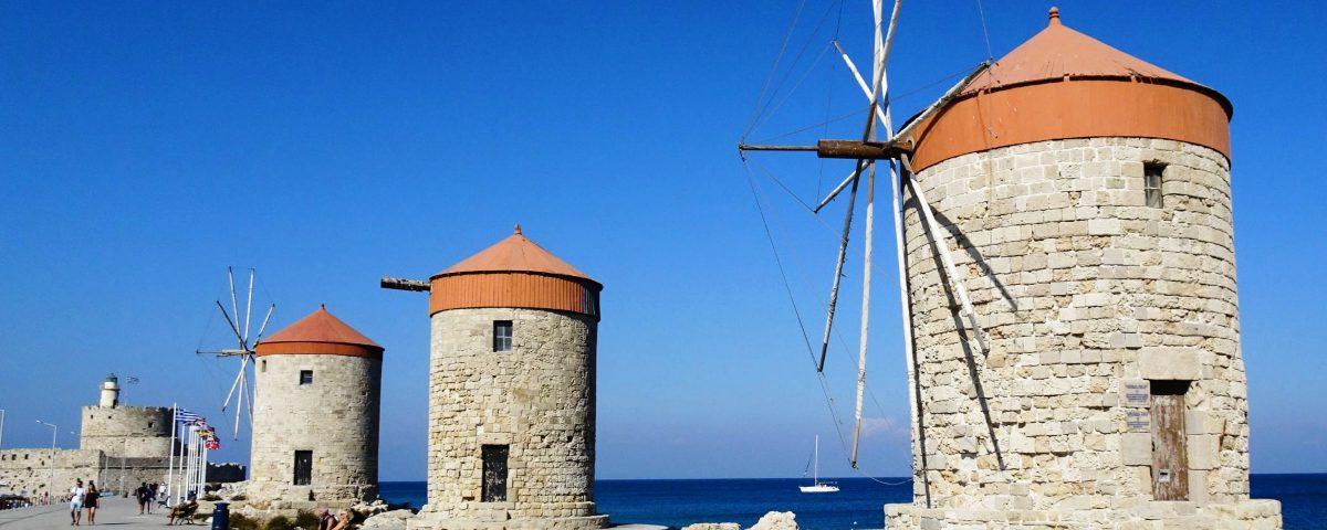 A beautiful view of the the Windmills of Mandraki and Fortress of St. Nicholas in Rhodes, Greece