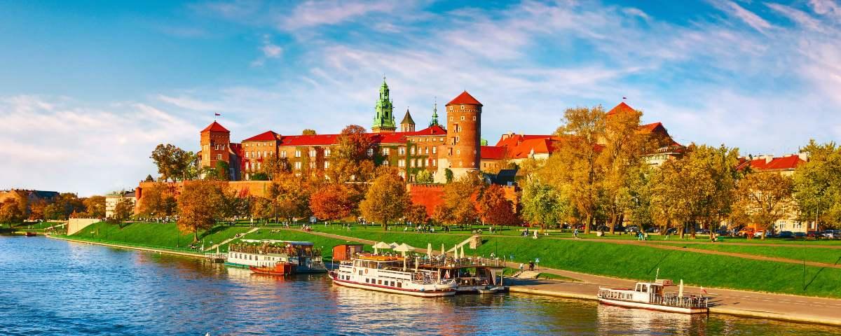 Wawel Castle in Krakow, as seen from the river. Kids will love this fairytale style castle with red and white walls, turrets and red roofs.