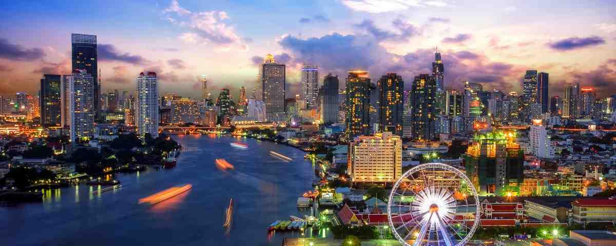 View of Bangkok skyscrapers, river and scenic big wheel at dawn or dusk