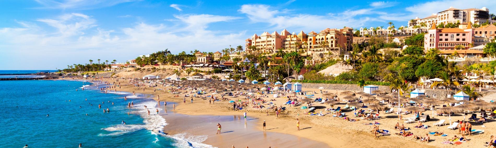 Holidaymakers swimming and relaxing on Playa del Duque in Tenerife, Canary Islands.