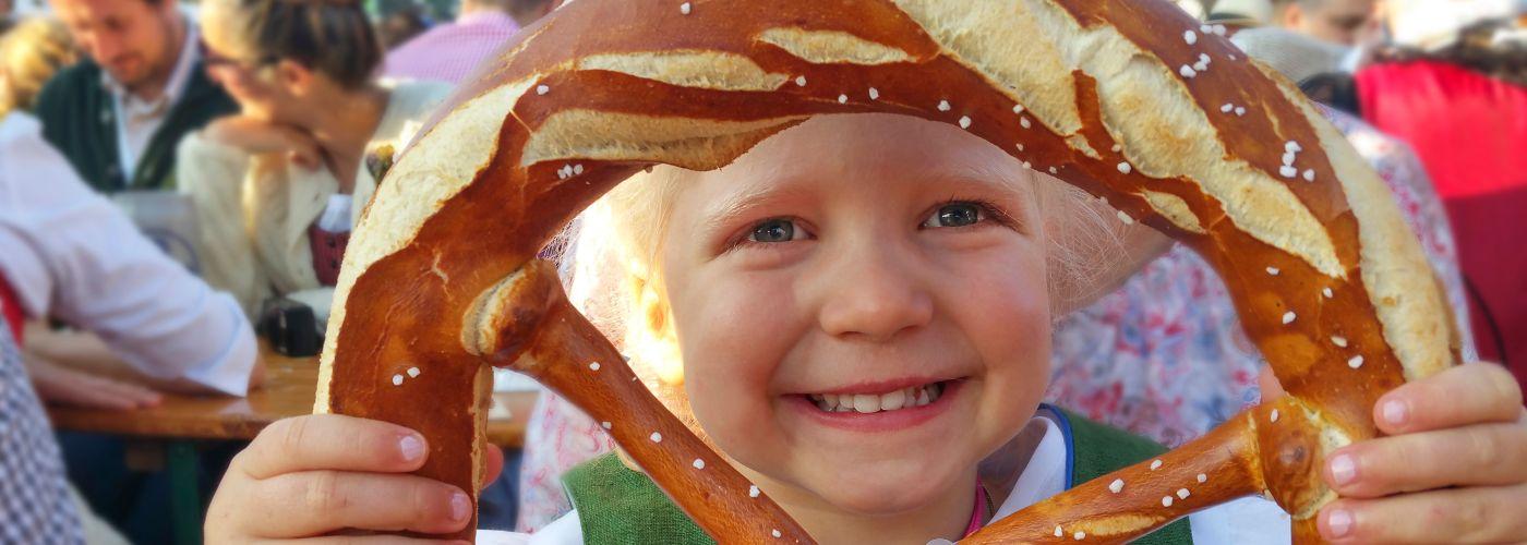 child holding up a large pretzel