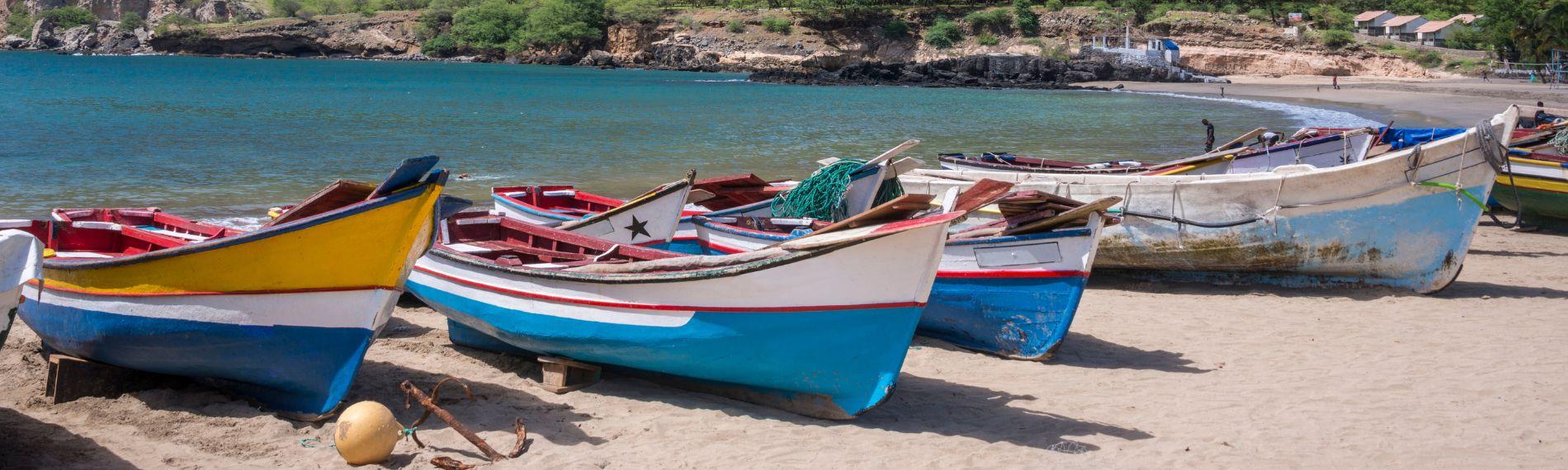 Painted wooden fishing boats lined up on the sand in Cape Verde, ideal for winter sun holidays.