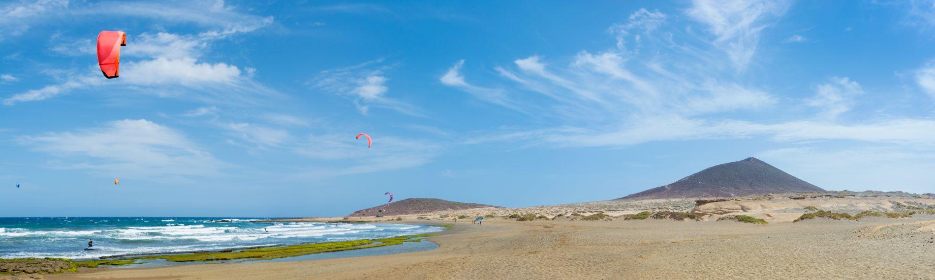 Kitesurfers at El Medano beach, a long, wide stretch of white sand with a view of Red Mountain (Montana Roja)