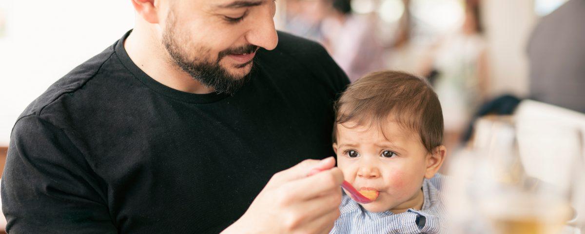 Dad feeding his baby in a restaurant 