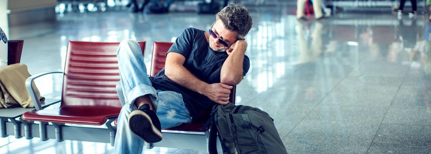 Man sleeping as he waits at the airport