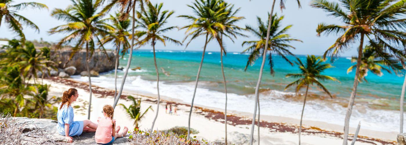 Mother and daughter relax on beach in Barbados