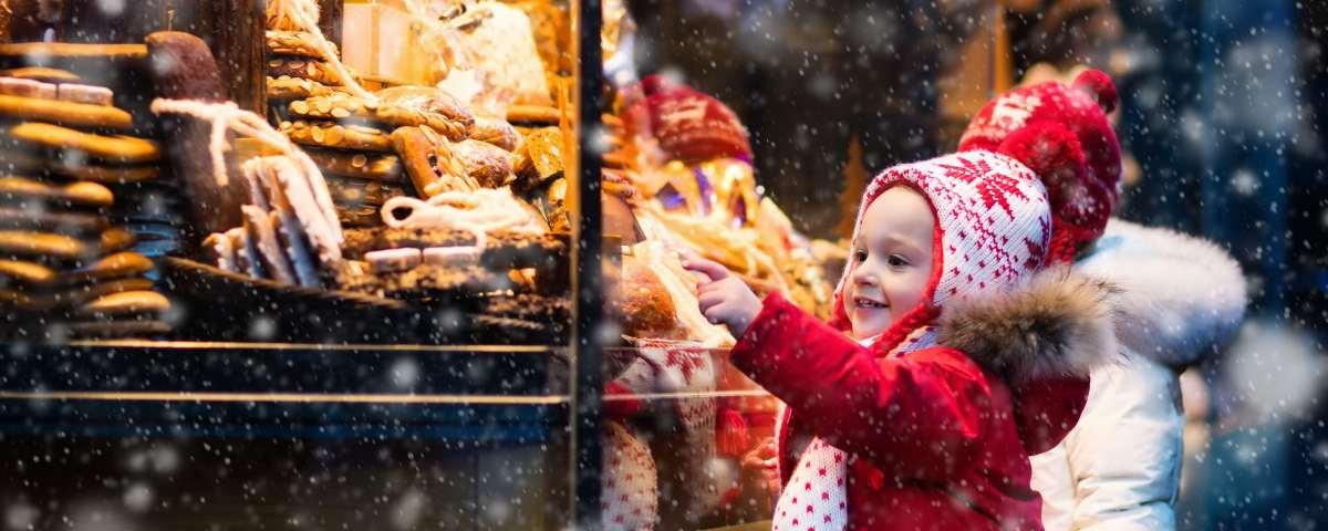 Kids choosing cookies from Christmas market stall