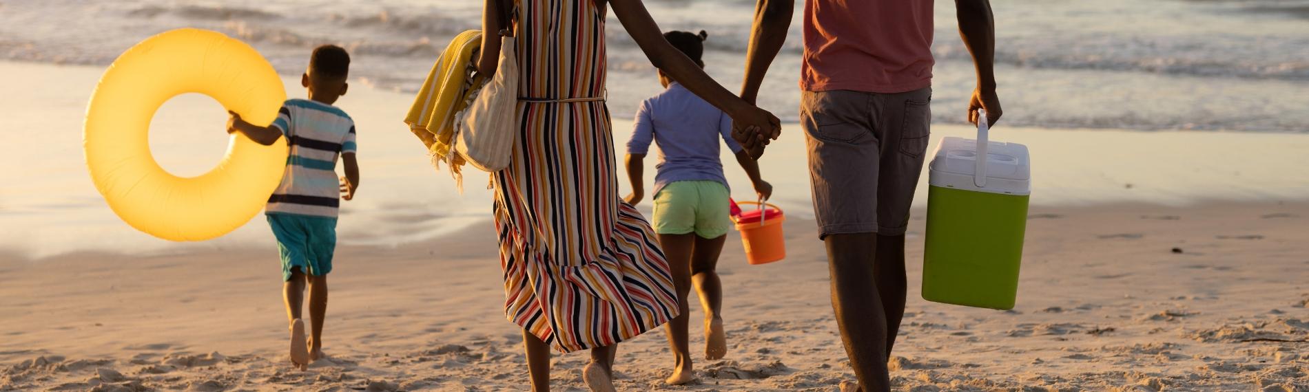 Family walking towards the sea on a sandy beach