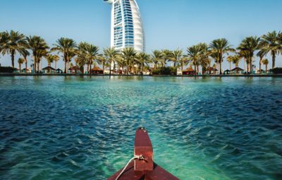 Boat on clear turquoise waters, Dubai skyline in the background, in October.