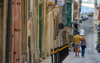 Couple walking down the streets of Valetta on their May holidays. 