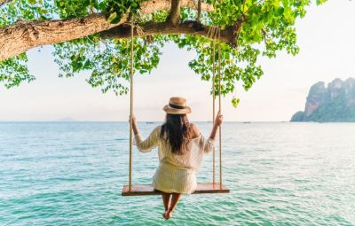 Woman on a swing over the sea in Thailand 