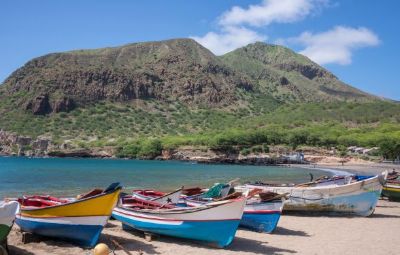 Cape Verde beach in October with boats on the sand and hilly scenery behind.