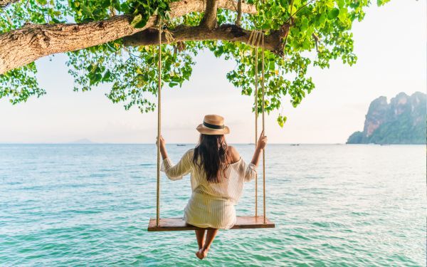 Woman on a swing over the sea in Thailand