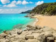 Sandy Costa Brava beach in Spain with clear blue water, a top sunny destination for a June holiday.
