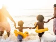 Family of four in the surf on a May half term beach holiday, ideal family destination with Thomas Cook.