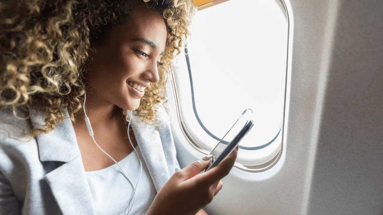 Person looking at her phone on airplane