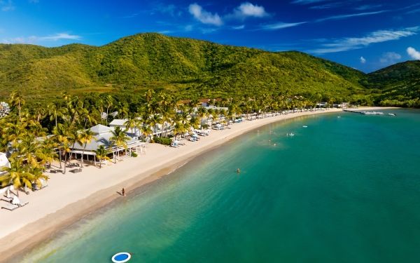 Peaceful beach in Antigua with clear waters and white sand, symbolising relaxation and awareness for World Mental Health Day.