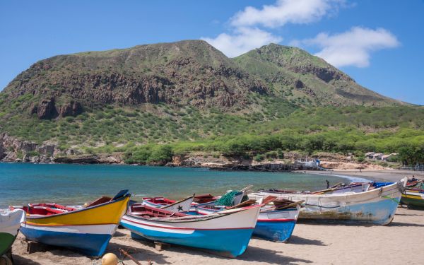 Cape Verde beach in October with boats on the sand and hilly scenery behind.