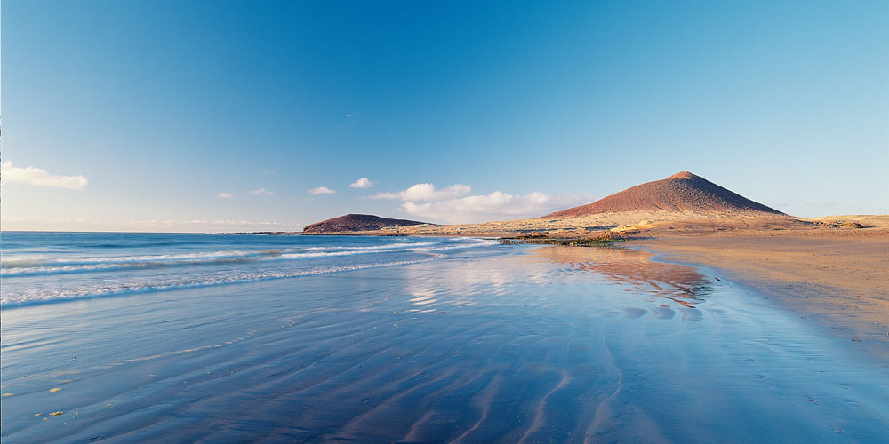 Tenerife beach with Mount Teide volcano in the background, October sunshine.