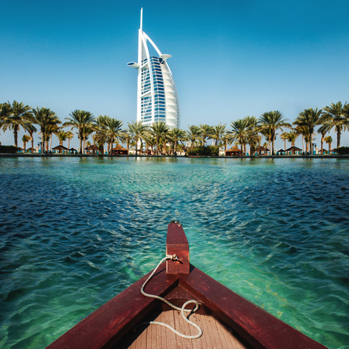 Boat on clear turquoise waters, Dubai skyline in the background, in October.